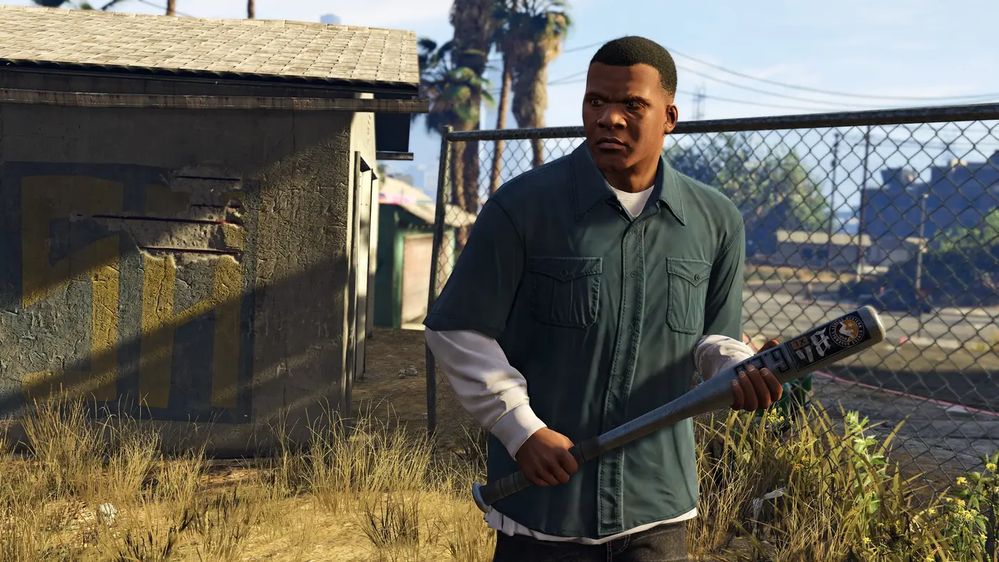 Franklin Clinton, baseball bat in hand, in a Los Santos yard with palm trees and a chain-link fence