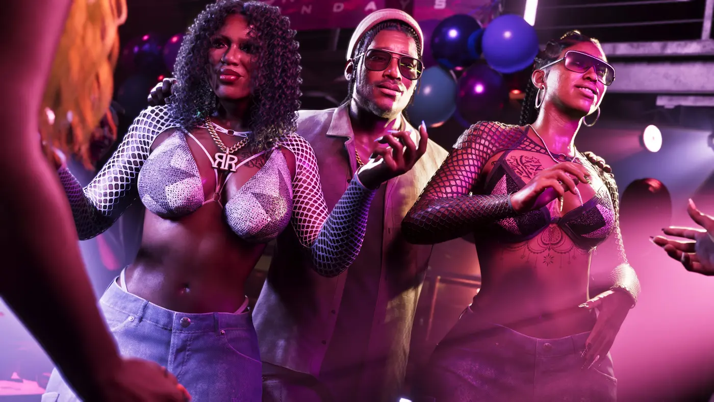 Nightclub scene in GTA VI: three characters pose for the camera under purple and pink lighting, two women in fishnet tops and gold jewelry flanking a man in a light jacket and sunglasses, party balloons and spotlights in the background