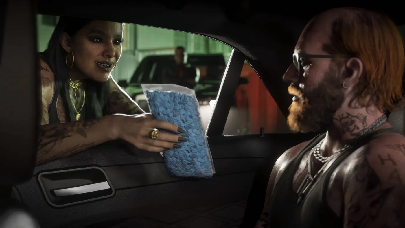 A tattooed woman leans into a car window to hand a clear baggie full of blue pills to a bearded man in a tank top, in a dark garage in GTA VI